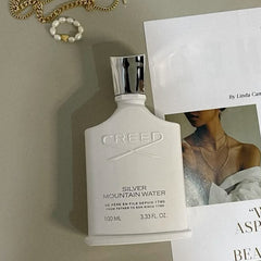 White bottle of Caudalie on a surface with a magazine and jewelry
Creed Silver Mountain Water Eau de Parfum is a vibrant blend inspired by the sparkling mountain landscapes of the Swiss Alps. Cool, refreshing, and quietly luxurious, it’s made for those who seek uniqueness, elegance, and confidence in every spray. This 100% authentic imported white box tester offers the full Creed experience without the boutique price tag.