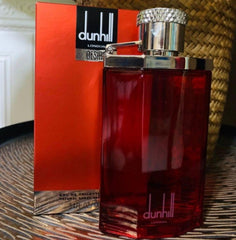 Red Dunhill perfume bottle and packaging on a textured surface with a plant in the background
Dunhill Desire Red Eau de Toilette is a captivating scent for the modern man who knows what he wants. A magnetic blend of fresh citrus, warm woods, and seductive musk, this 100% authentic imported tester is both charismatic and timeless without the luxury price tag.