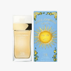 A product image showing Dolce & Gabbana Light Blue Sun Eau de Toilette, with the bottle in front of its packaging. The packaging has a blue color with an illustration of a sun and the text 'Dolce & Gabbana'.