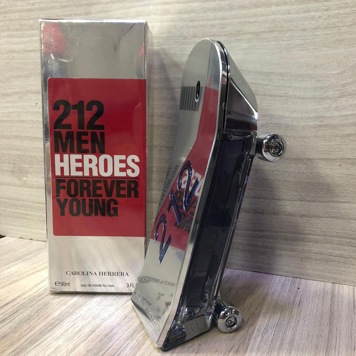 Perfume bottle and packaging of Carolina Herrera 212 Men Heroes Forever Young on a wooden surface.
212 Heroes Forever Young by Carolina Herrera is a vibrant, playful, and modern scent designed for men who live life with passion and energy. Bursting with fruity freshness, aromatic herbs, and a daring leather base, this 100% authentic imported tester embodies youthful rebellion and fearless style all at an unbeatable value.