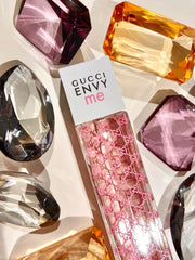 Gucci Envy Me perfume bottle with colorful gemstones in the Gucci Envy Me Eau de Toilette is a youthful and flirty blend of sweet fruits, delicate florals, and soft woods. Designed for the confident, modern woman who loves to stand out, this 100% authentic imported tester combines high-end quality with unbeatable value without the luxury price tag.background