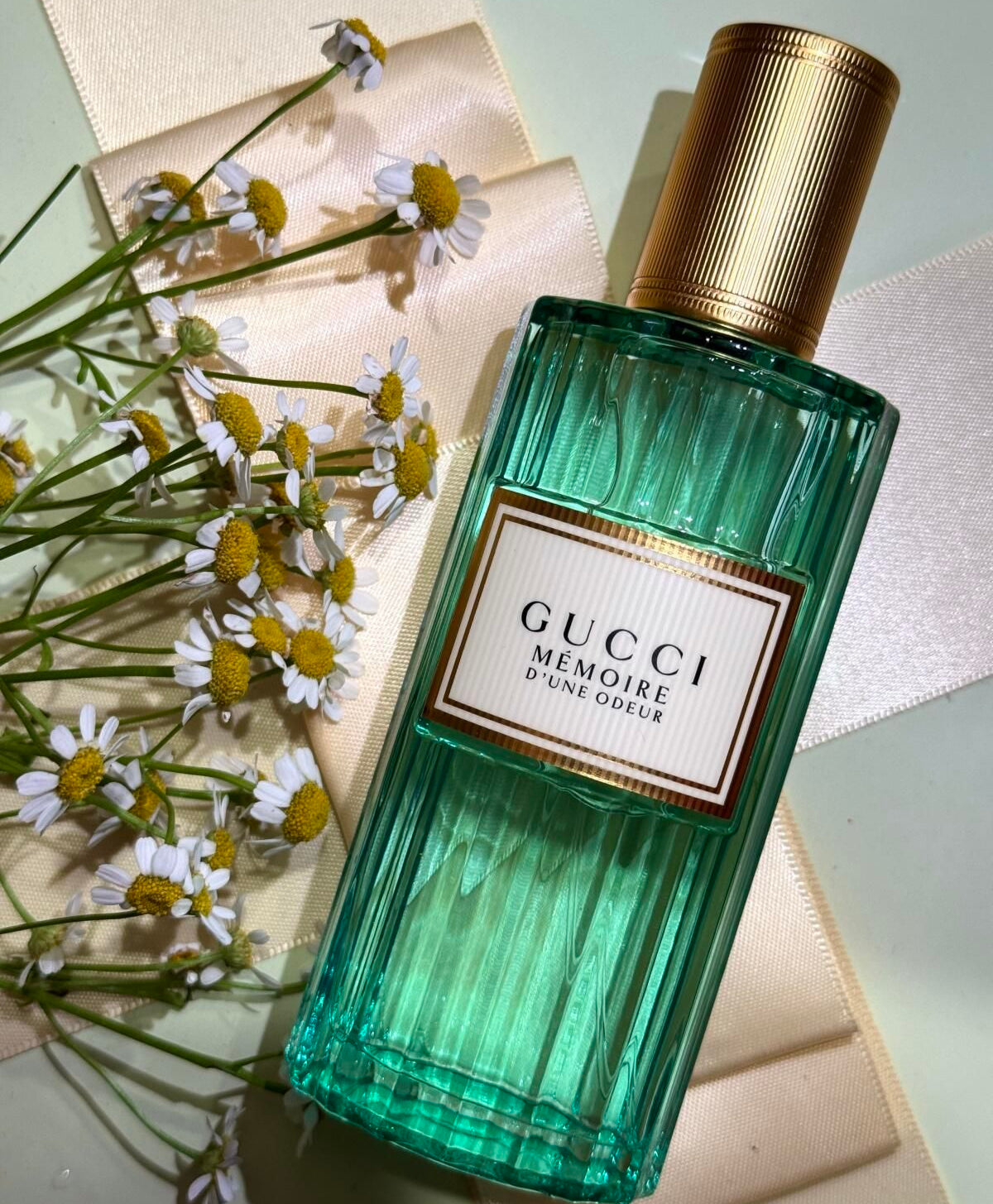 Green Gucci perfume bottle with gold cap on a light background
Gucci Mémoire D’une Odeur Eau de Parfum is a boundary-breaking scent that blends the unexpected softness of Roman chamomile with musky florals and warm woods. Designed for all genders, it evokes a feeling more than a formula. Soft, dreamy, and deeply personal. This 100% authentic imported tester offers Gucci’s signature artistry at an unbeatable value.