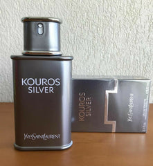 Yves Saint Laurent Kouros Silver perfume bottle and packaging on a wooden surface with a textured wall background.
Kouros Silver Eau de Toilette by Yves Saint Laurent is a dynamic reinterpretation of a classic scent. It opens with vibrant fruity freshness, evolves into aromatic elegance, and settles into a warm, woody base. Crafted for the confident and contemporary man, this 100% authentic imported tester offers legendary YSL quality without the designer markup.
