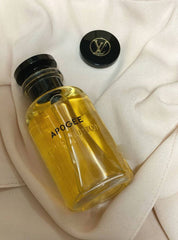 Yellow bottle labeled 'Apogee' on a white surface Louis Vuitton Apogée Eau de Parfum is a graceful and luminous scent that captures the essence of blooming florals in springtime. With fresh citrus top notes of Tangerine and Orange, a floral heart of Lily-of-the-Valley, Magnolia, Rose, and Jasmine, base of White Musk, Guaiac Wood, and Sandalwood—this perfume embodies effortless sophistication and charm. This 100% authentic, imported tester offers luxurious quality, strong performance, and captivating beauty 